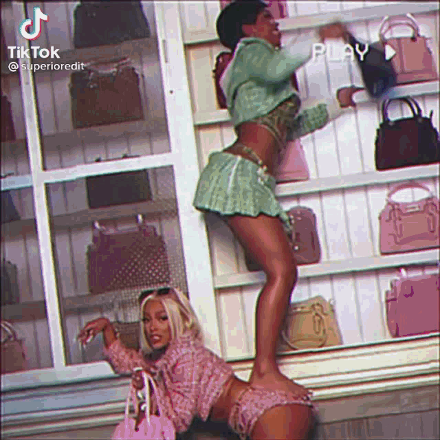 two women are standing in front of a wall of handbags .