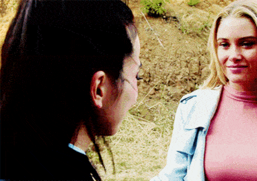 two women are looking at each other and one is wearing a pink top