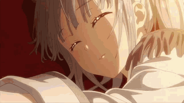 a close up of a girl sleeping in a bed with her eyes closed