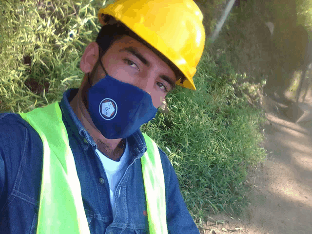 a man wearing a yellow hard hat and a blue mask with a logo that says ' a ' on it