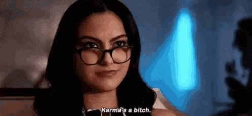 a woman wearing glasses is talking to someone and says `` karma 's a bitch '' .
