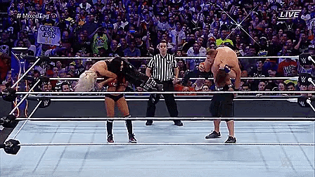 two wrestlers in a wrestling ring with a sign that says crossed jesus on it