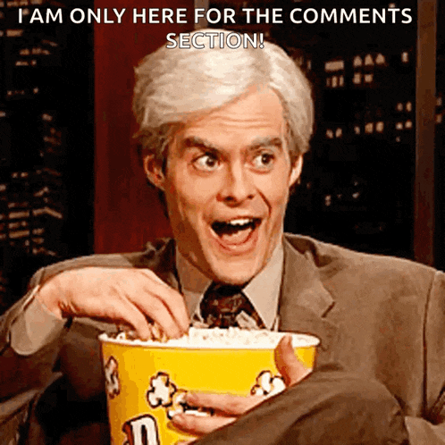 a man in a suit is holding a bucket of m & m 's popcorn