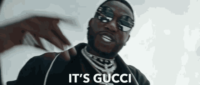 a close up of a man wearing sunglasses with the words it 's gucci below him