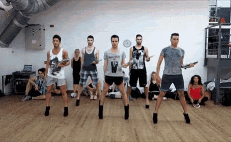 a group of men wearing high heels are dancing