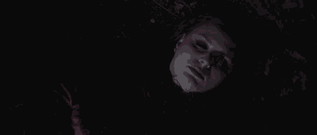 a woman is laying on the ground with blood on her face and body .