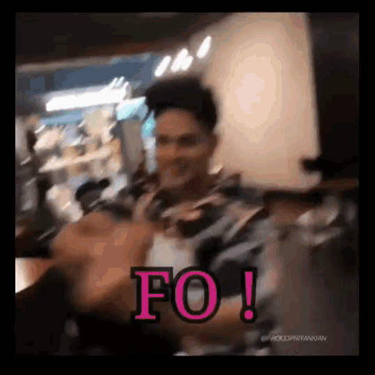 a man in a plaid shirt is giving the middle finger in a blurry photo with the words " fo " on the bottom .