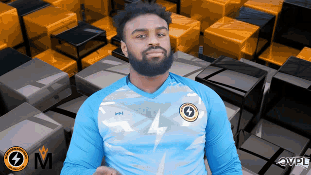 a man wearing a lightning bolt shirt stands in front of a stack of boxes