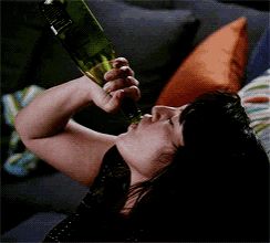 a woman is drinking from a bottle with a label that says ' jameson '