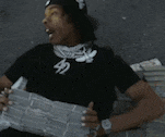 a man wearing a black shirt with the number 42 on it is reading a newspaper .