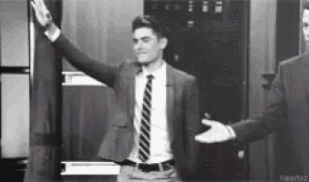 a man in a suit and tie giving a high five