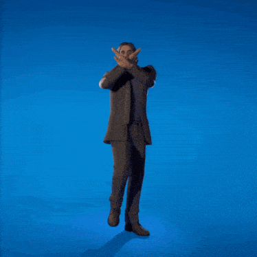 a man in a suit and tie stands with his arms in the air