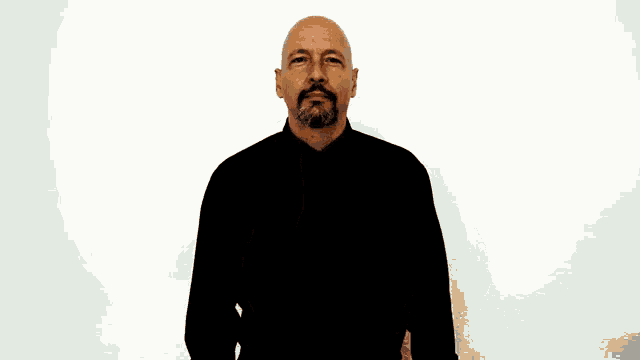 a bald man with a beard is wearing a black shirt