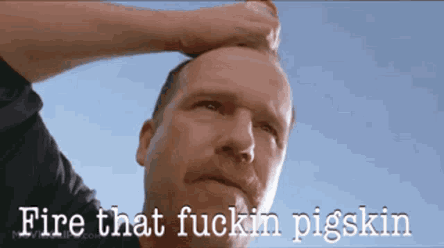 a man with a mustache is holding a bottle to his forehead with the words fire that fuckin pigskin written below him