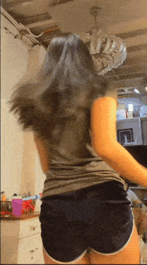 a woman in shorts is dancing in a room