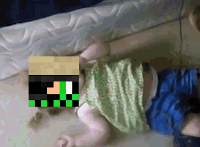 a baby is laying on the floor with a pixelated image of a minecraft character