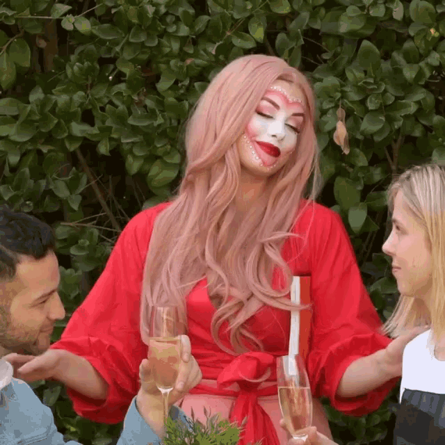 a woman with pink hair has a heart painted on her face while holding a glass of champagne