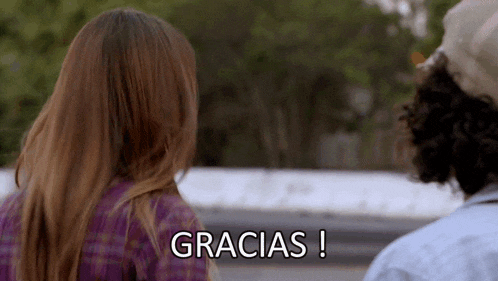 a man and a woman are standing next to each other and the woman says gracias !