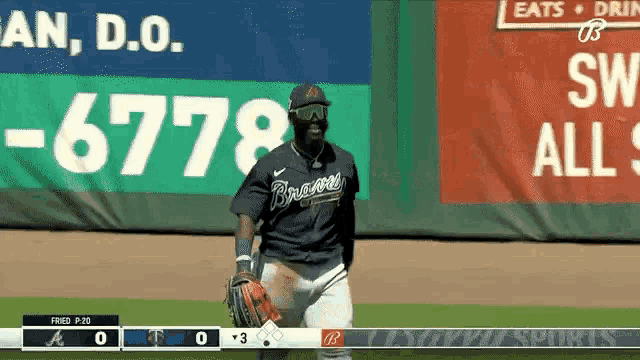 a baseball player wearing a braves jersey is standing on the field