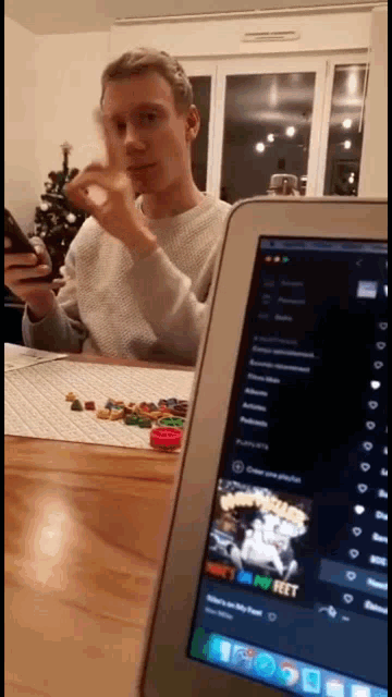 a man sitting at a table with a tablet that says netflix