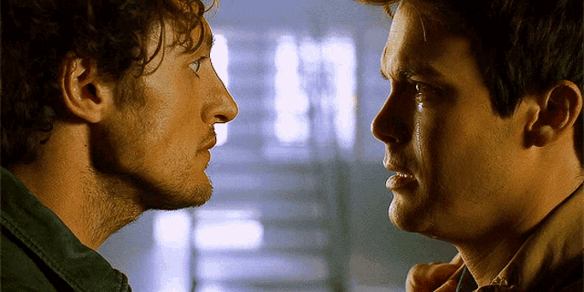 two men are looking at each other and one has a tear coming out of his eye