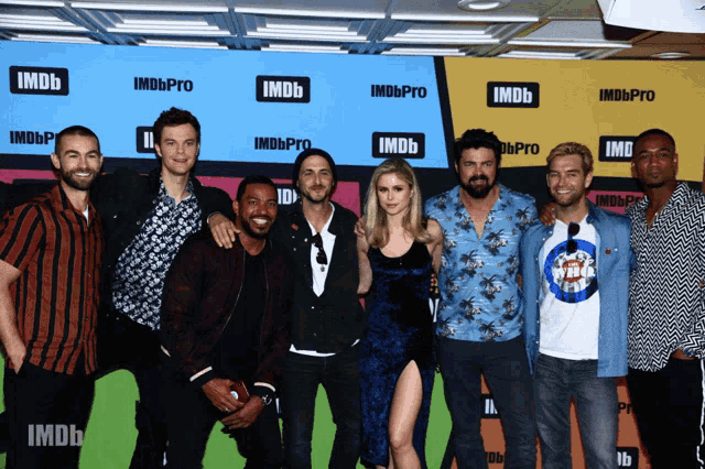 a group of people standing in front of a wall that says imdb