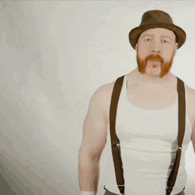 a man with a beard wearing a hat and suspenders is holding a rope