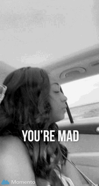 a black and white photo of a woman in a car with the words " you 're mad " above her