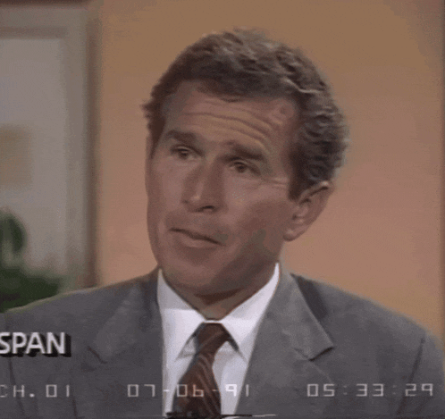 a man in a suit and tie is making a face in front of a screen that says " span "