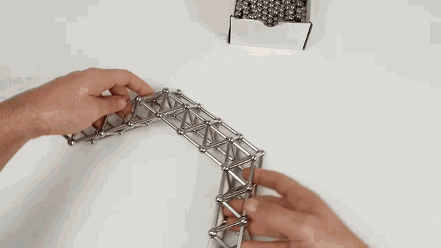 a person is playing with a magnetic toy that looks like an arrow