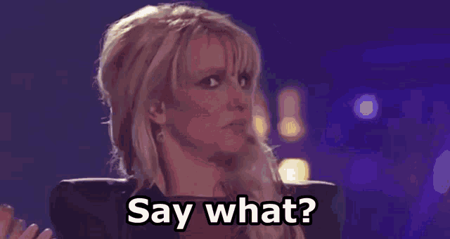 a woman is standing in front of a microphone and saying " say what " .