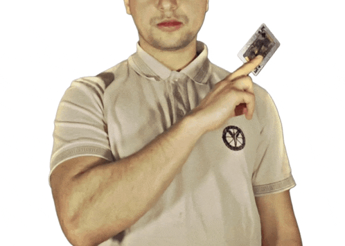 a man in a polo shirt is holding a cassette tape in his right hand