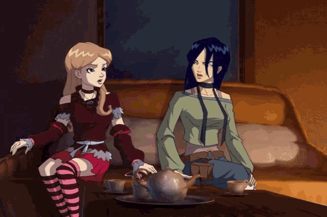 a couple of girls sitting on a couch with their arms crossed