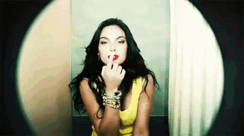 a woman in a yellow dress is blowing a kiss