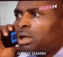 a man is talking on a cell phone and making a funny face .