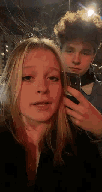 a boy and a girl are taking a picture together