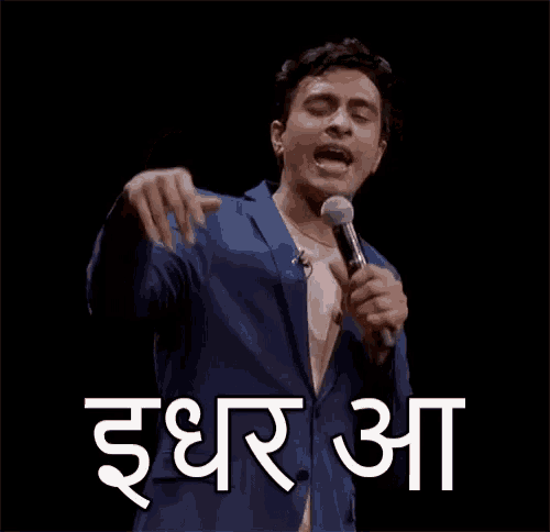 a man in a blue suit is holding a microphone and making a funny face in a foreign language .