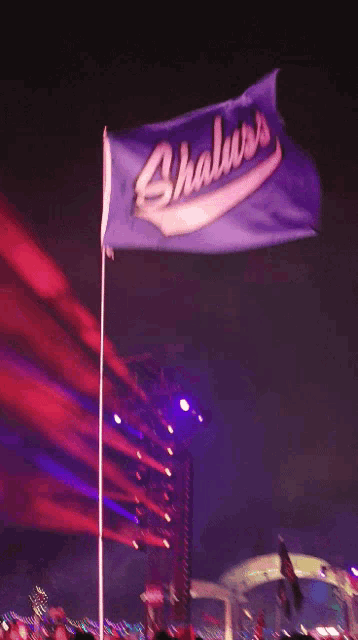 a purple flag that says shaluss is flying in the wind