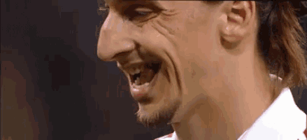 a close up of a man 's face with a ponytail