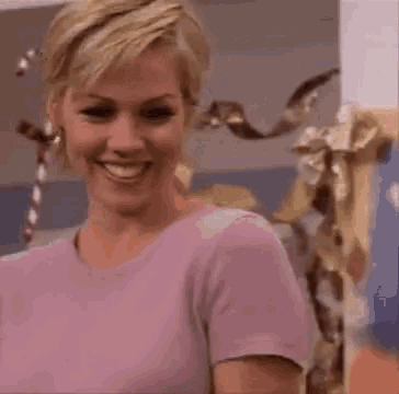 two women are standing next to each other in a room with a painting on the wall