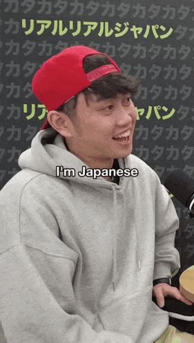 a man wearing a red hat and a hoodie says i 'm japanese