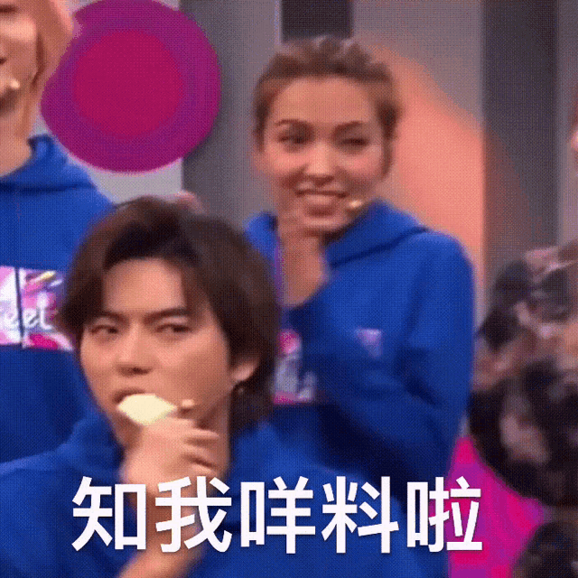 a man in a blue hoodie is eating ice cream while a woman looks on
