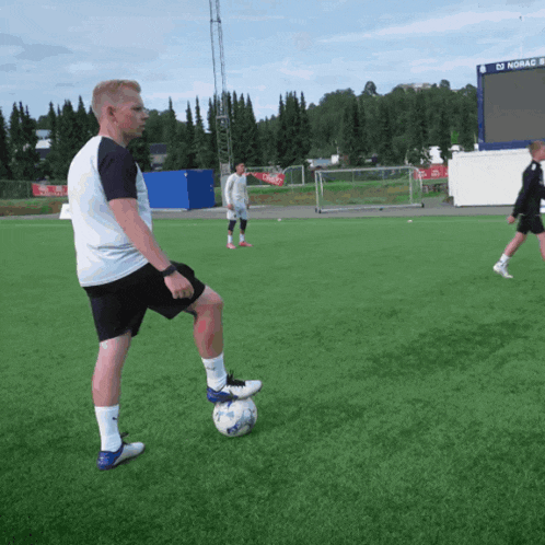a group of soccer players on a field with a scoreboard in the background that says ' 02 rogaland ' on it
