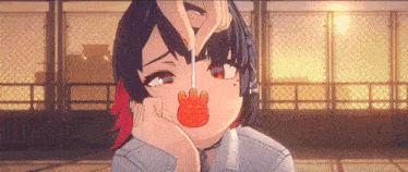 a girl with red hair is eating a lollipop with a cat on it .
