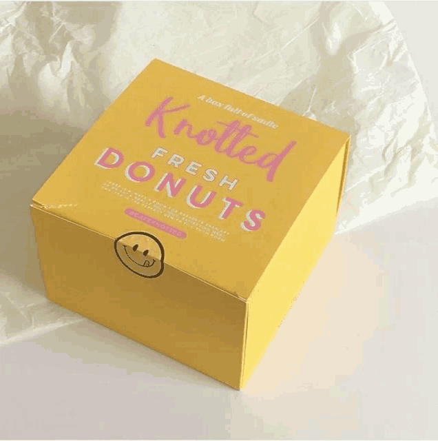 a box full of knotted fresh donuts sits on a piece of paper