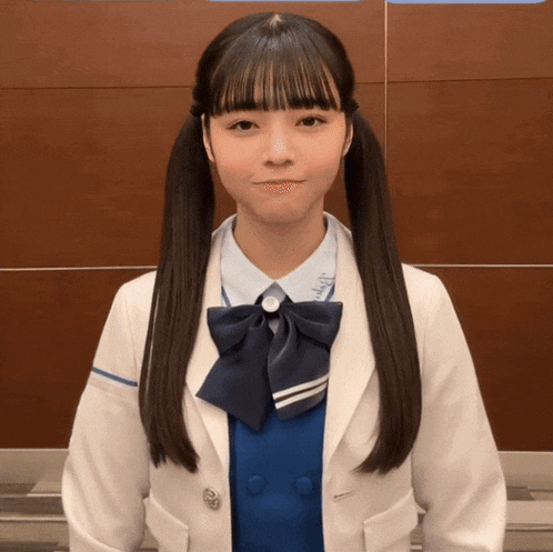 a girl with pigtails wearing a white jacket and blue shirt