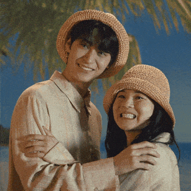a man and a woman wearing straw hats are hugging each other