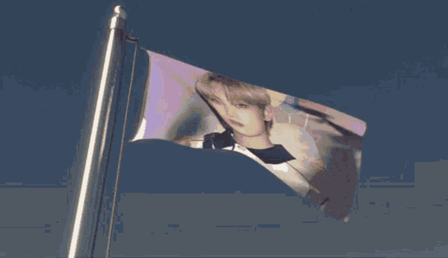 a flag with a picture of a man on it is waving in the wind