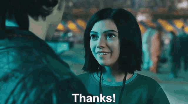 a woman in a green sweater is smiling and says thanks