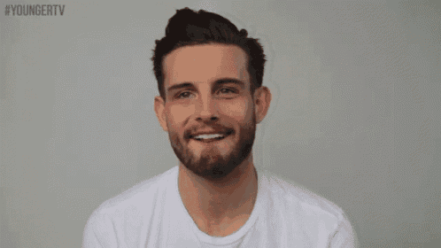 a man with a beard wearing a white t-shirt with the hashtag youngertv on the bottom